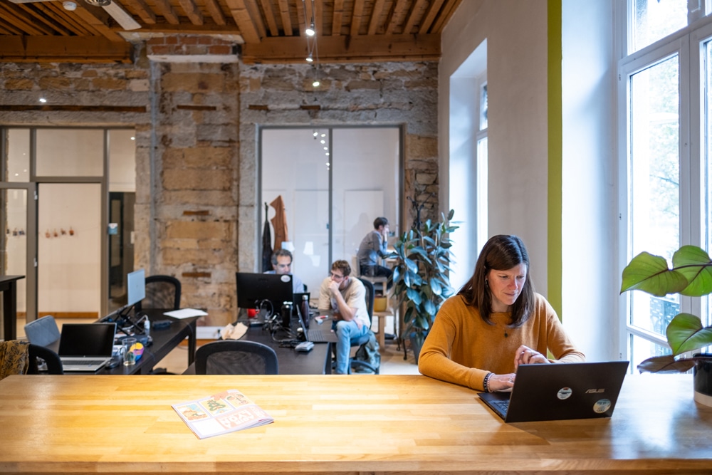 Des télétravailleurs, indépendants, entrepreneurs, travaillent ensemble en flex desk dans les locaux de La Cordée coworking.